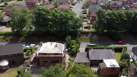 Builders-working-on-new-home-rooftop-aerial-view-circling-above-modern-red-brick-house-development-renovation