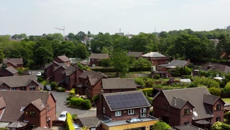 British-red-brick-woodland-townhouse-development-neighbourhood-aerial-view-circling-above-solar-panels-on-new-home-rooftop