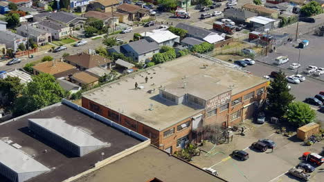 Firefighters-extinguishing-fire-on-large-warehouse-in-the-city,-aerial-view