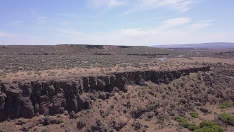 Aerial-descends-to-low-rock-bluffs-in-Channeled-Scablands,-central-WA