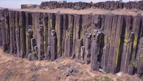 Aerial-rotates-along-lichen-covered-basalt-column-cliff-in-WA-state