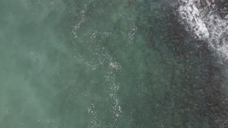 Aerial-Above-Clear-Blue-Waters-Of-The-Coral-Sea-With-Waves-Splashing-At-Burleigh-Beach-In-Gold-Coast,-Queensland