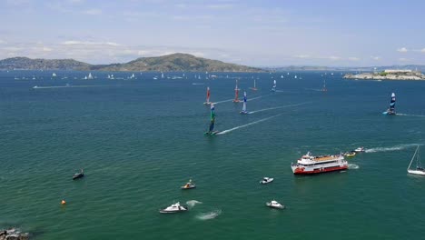 Vista-Aérea-Panorámica-Sobre-Los-Barcos-Observando-A-Los-Equipos-Del-Grand-Prix-De-Vela-De-San-Francisco-Navegar-Por-La-Costa.