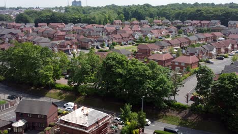 Builders-working-on-new-home-rooftop-aerial-view-tilt-up-to-modern-red-brick-housing-development-neighbourhood