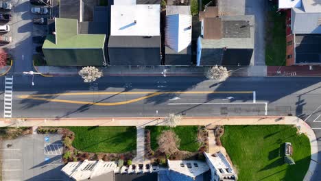 Silence-around-the-main-street-of-a-small-town-in-America-in-the-afternoon-due-to-summer-heat-and-harsh-sunlight,-USA,-top-down-aerial-view