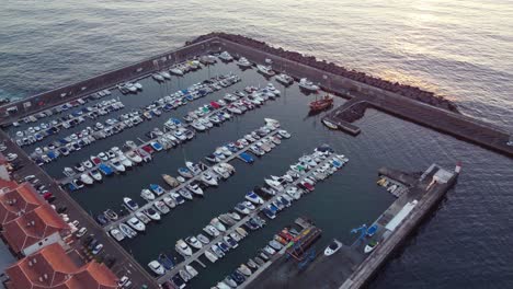 Aerial-view-of-yacht-harbor-in-Los-Gigantos,-Tenerife,-with-setting-sun