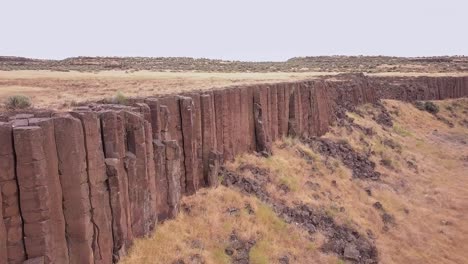 Centuries-of-erosion-debris-at-base-of-basalt-rock-columns,-central-WA