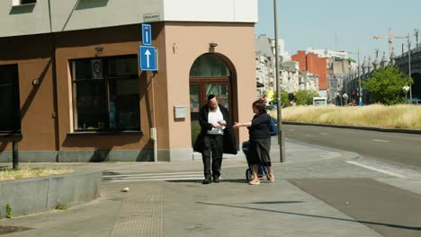 Jewish-couple-walking-in-the-Diamond-district-in-Antwerp,-Belgium-on-a-sunny-day