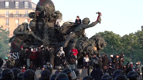 Protesters-scale-a-statue-in-Bulevar-Voltaire-during-the-May-Day-protest-in-Paris,-France