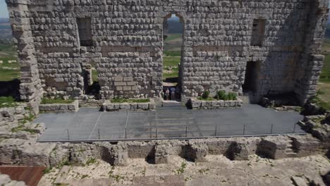 Die-Drohne-Steigt-Herab-Und-Enthüllt-Eine-Atemberaubende-Landschaft,-Während-Touristen-Im-Teatro-Romano-Zusehen