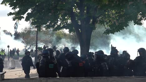 Clouds-of-tear-gas-and-riot-police-during-the-May-Day-protests-in-Paris,-France