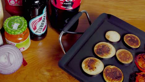 Sideways-pan-of-electric-tabletop-griddle-cooking-burgers-and-vegetables