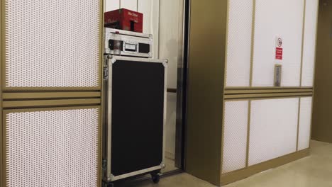 Mann-Zieht-Flightcases-Und-Kartons-In-Einen-Aufzug-Für-Eine-Live-Streaming-Veranstaltung