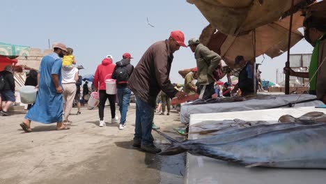 Close-up-of-table-at-busy-fish-market-at-port-of-Essaouira,-Morocco