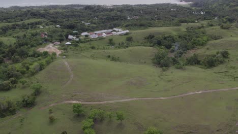 Tilt-up-shot-of-green-scenery-at-Sumba-island-Indonesia-during-cloudy-day,-aerial