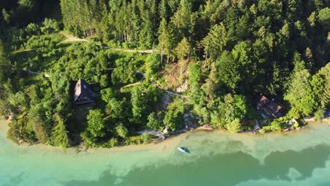 Aerial-bird's-eye-view-of-summertime-lake-house-facing-emerald-lake,-Austria