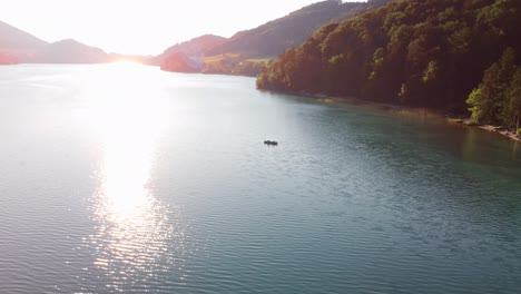 Summertime-water-canoe-in-middle-of-lake-in-Austria,-aerial-view,-golden-hour
