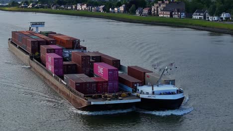 A-loaded-container-ship-sailing-through-River-Noord,-Aerial-View