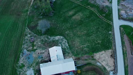 Aerial-Above-Farmhouse-On-Green-Field-In-Norway