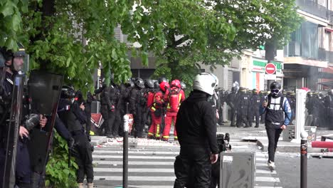 A-security-guard-watches-over-a-journalist-filming-the-May-Day-protest-in-Paris,-France