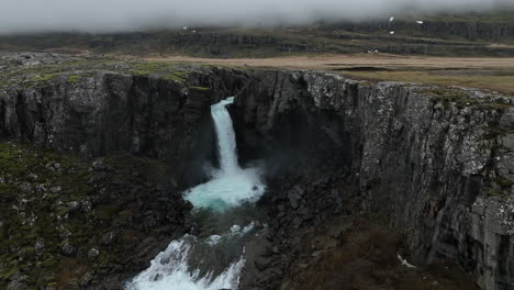 Folaldafoss-Waterfall:-A-zoom-out-aerial-shot-of-the-beautiful-Icelandic-waterfall-on-a-cloudy-day