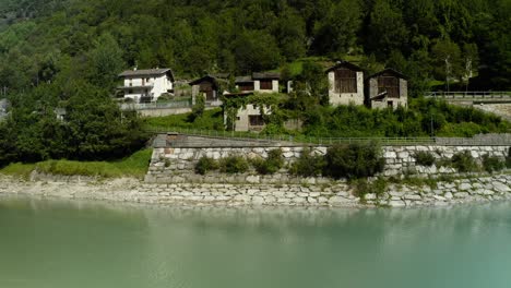Aerial-Over-Mera-River-With-View-Of-Traditional-Homes-On-Shoreline