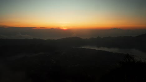 Slow-panorama-shot-on-mount-batur-in-bali,-indonesia-overlooking-the-beautiful-golden-hour-sunrise
