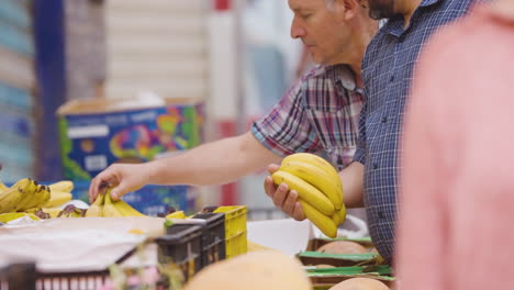 Männer-Kaufen-Frische-Bananen-Am-Obststand-Auf-Dem-Markt-Von-Ghardaia,-Algerien