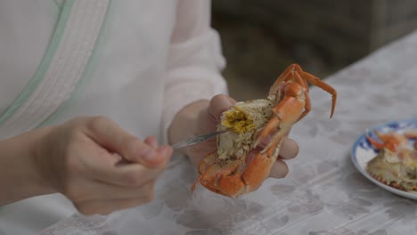 Taking-out-steam-cooked-crab-brain-out-with-a-spoon-and-plating-on-a-dish