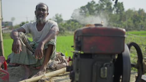 Bangladeschischer-Armer-Bauer-Sitzt-An-Einer-Wasserpumpe-Und-Spendet-Wasser-Für-Das-Grüne-Reisfeld-–-Landwirtschaftliches-Wachstum-In-Bangladesch