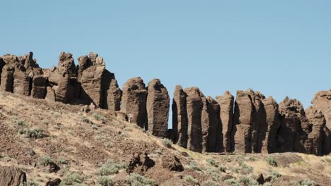 Tourist-walks-at-base-of-huge-basalt-rock-pillars-in-central-WA-state