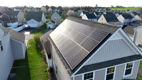 Solar-panels-producing-energy-on-rooftop-of-classic-american-home,-slow-aerial,-push-in