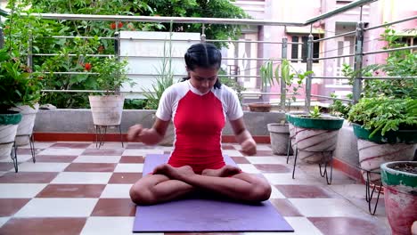 Front-view-of-a-young-Indian-girl-doing-yoga-wearing-sports-clothes,-doing-Kapalbhati-yoga-which-makes-breathing-easier-and-is-also-very-good-for-health