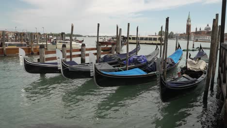 Venice-Grand-Canal-scene,-close-up-of-Gondolas-boats-floating-with-view-of-city