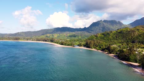 Breathtaking-Aerial-shot-of-Hanalei-Bay-and-green-mountains,-beach,-boat,-ocean-with-the-Hanalei-River-near-Princeville,-Kauai,-Hawaii