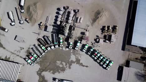 aerial-view-of-a-cement-production-facility,-with-trucks,-heavy-machinery,-stones,-sand,-bulldozers