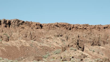 Blue-sky-hiker-walks-along-rim-of-Frenchman-Coulee-in-WA-Scablands