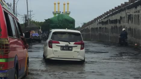 Einige-Fahrzeuge-Und-öffentliche-Verkehrsmittel-Fahren-Durch-Flutfluten-In-Der-Stadt-Semarang,-Zentral-Java,-Indonesien