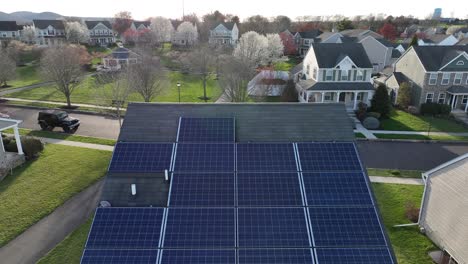 Rooftop-solar-panels,-aerial-revealing-shot-of-american-suburban-neighborhood-in-spring