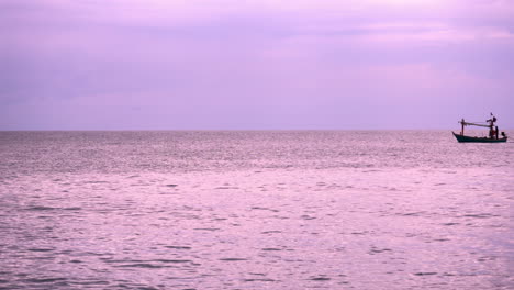 Rosafarbenes-Meer-Bei-Sonnenuntergang-Mit-Der-Silhouette-Eines-Thailändischen-Fischerbootes,-Das-An-Einem-Bewölkten-Tag-Hinüberfährt