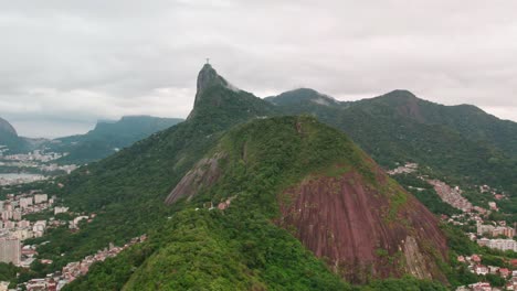Dolly-in-aerial-view-of-the-dense-mountains-with-Corcovado-hill-and-Christ-the-Redeemer,-Rio-de-Janeiro,-Brazil,-cloudy-day