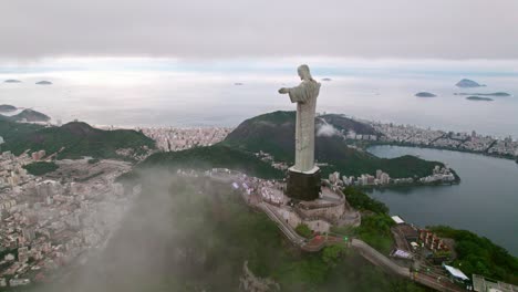 Aerial-orbit-establishing-Christ-the-Redeemer-and-Rio-de-Janeiro-in-the-background-on-a-cloudy-day-Brazil,-tourist-spot-in-the-Wonder-of-the-World