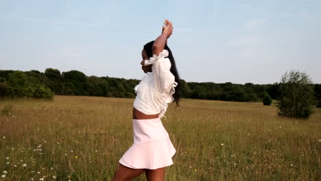 Black-woman-posing-for-camera-in-yellow-field-during-a-warm-sunny-day-during-sunset