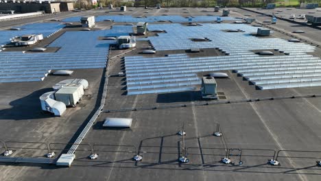 Large-solar-panel-installation-and-HVAC-on-industrial-rooftop,-aerial-establishing-shot