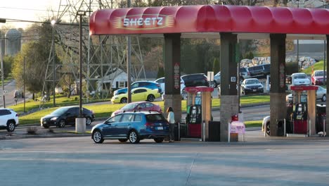 Woman-fueling-car-at-Sheetz-gas-station,-dolly-right