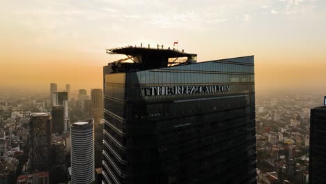 Aerial-view-toward-people-on-top-of-the-Ritz-Carlton-hotel,-sunset-in-Mexico-city
