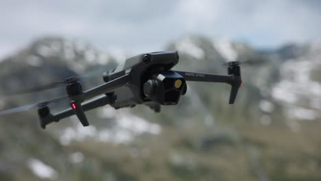 DJI-Mavic-3-Pro-Hovering-In-Air-With-Bokeh-Background-Of-Snow-Capped-Mountains-In-Switzerland