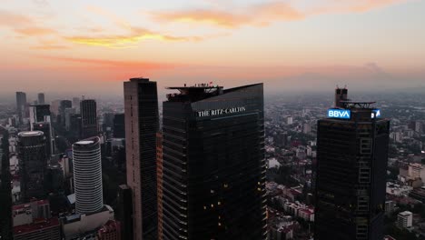 Aerial-view-around-the-Ritz-Carlton-building,-vibrant-evening-in-Mexico-city---orbit,-drone-shot