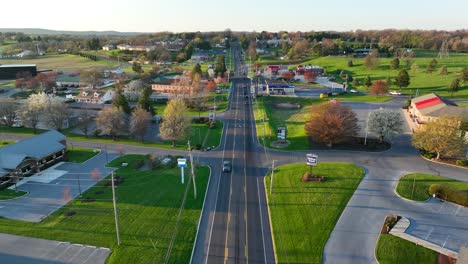 Descending-aerial-of-main-street-in-small-town-in-America-during-spring-sunset