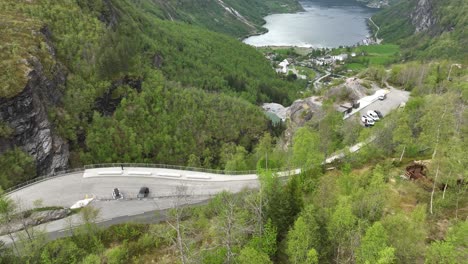 Tourists-enjoying-Flydalsjuvet-viewpoint-in-Geiranger-Norway---Geiranger-fjord-in-background---Aerial